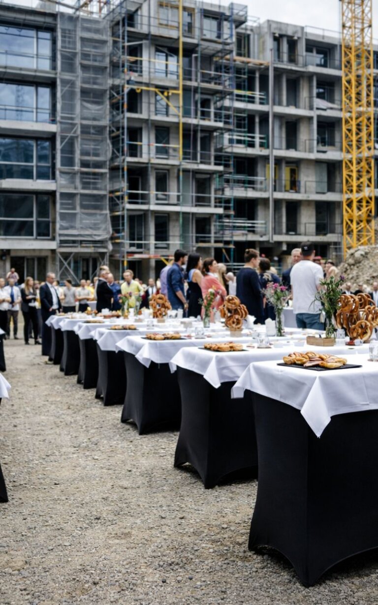 Catering auf Richtfest mit Buffet und Gästen vor Baustelle